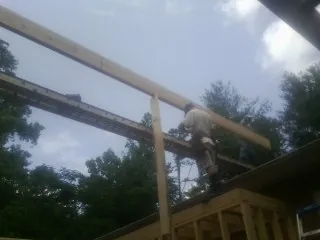 Carpenter setting a ridge beam over a new addition frame — Ice Dam Removal by Roofing Brothers in Reno