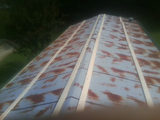 Rusted metal roof panels with new wood purlins before replacement — Storm Damage Roof Repair in Reno by Roofing Brothers